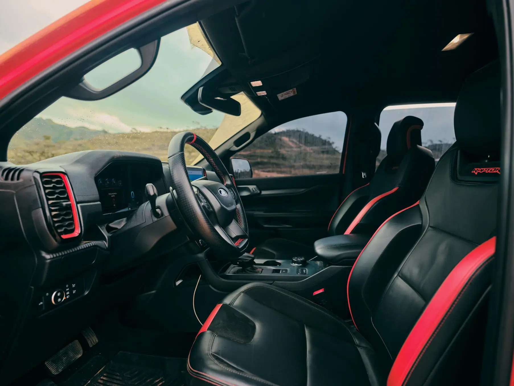 Interior esportivo com bancos em couro preto com detalhe em vermelho da Ford Ranger Raptor